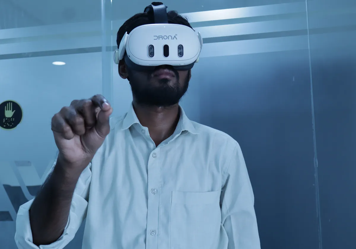 Trainee in a white Drona VR headset using a hand-tracking pinch gesture during a training session